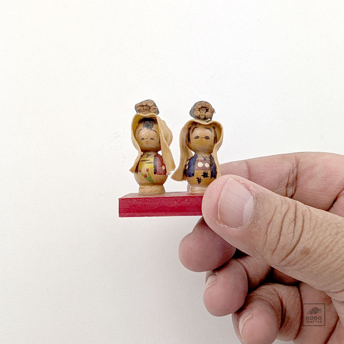 Vintage Kokeshi Pair on Red Platform